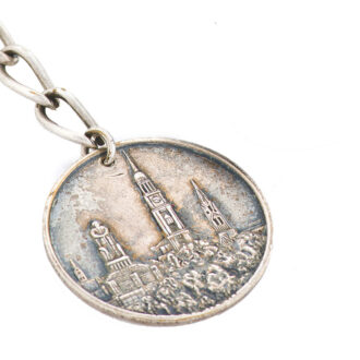 Accompanied by a silver chain and medallion fob