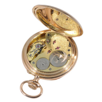 White enamel dial with black Roman hours, outer red Arabic five-minute numerals, inner red Arabic 24-hour markers and subsidiary seconds at 6 o'clock.